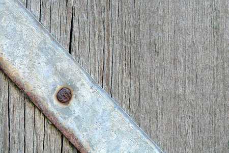 Metal plate with screws over the wooden background
