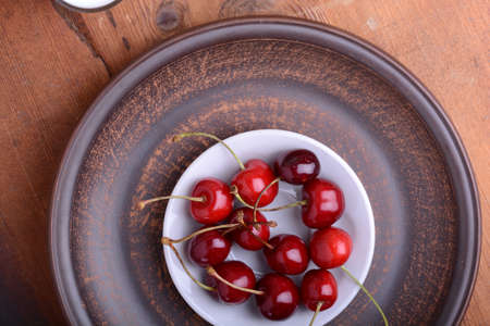 Fresh cherry on wooden plate. fresh ripe cherries. Top view. sweet cherries.の写真素材