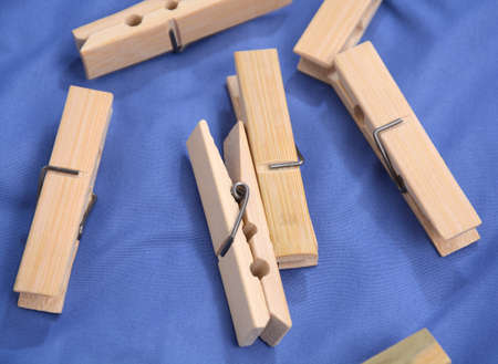 Wooden clothes pin. Closeup pin set on blue background