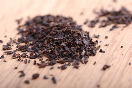 Earl grey black dry tea leaves on wooden plate close upの写真素材
