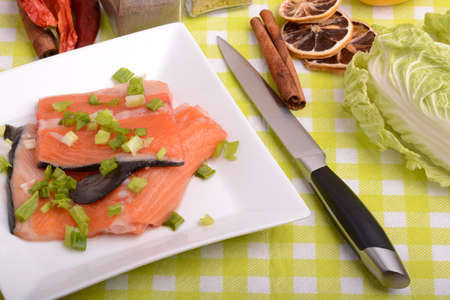 Food concept: red salmon fish, lemon and cabbage with red hot chilli pepper with greens. Healthy food cooking.の写真素材