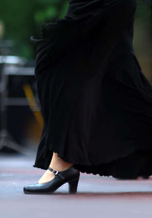 Flamenco dancer in the movement. Black skirt and black shoes. Focus on shoe. Background out of focus.の写真素材