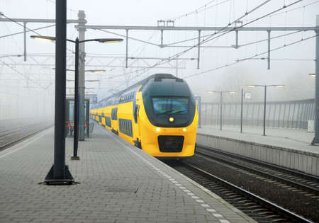 Yellow Dutch train and central station platform in Amsterdamの写真素材