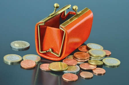 Opened leather purse with some euro coins aroundの写真素材