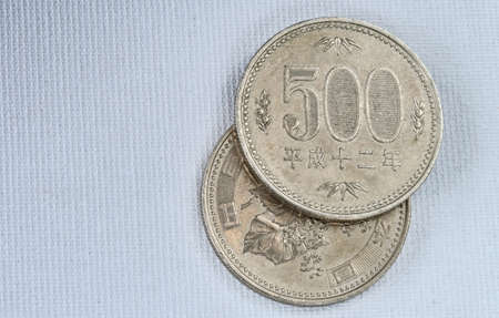Five hundred Yen coins on japanese paper background  Macro image の写真素材