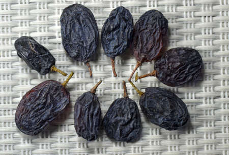 Group of dry seedles grapes on light gray mat.の写真素材