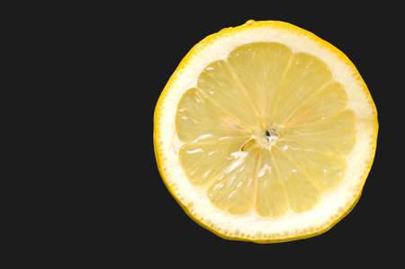 Fresh slice of lemon on black backgroundの写真素材
