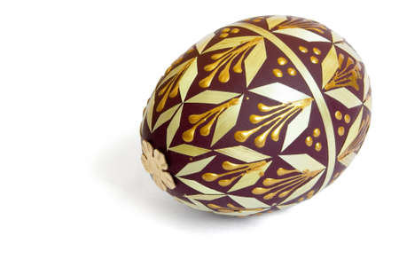 Brown easter  egg decorated golden paint and veneer isolated on whiteの写真素材