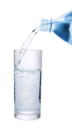 Sparkling water pouring into  glass isolated on whiteの写真素材