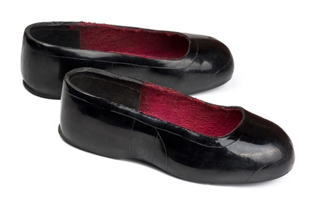 Old black rubber galoshes isolated on whiteの写真素材