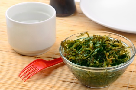 Still life with seaweed salad and cup of waterの写真素材