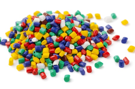 Pile of colorful plastic polymer granules isolated on white