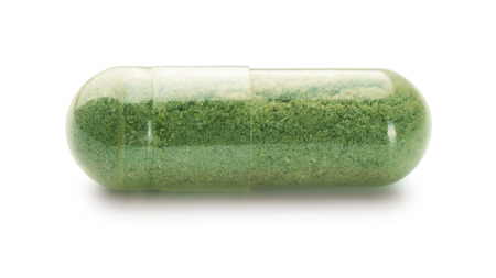 Single herbal capsule isolated on whiteの写真素材