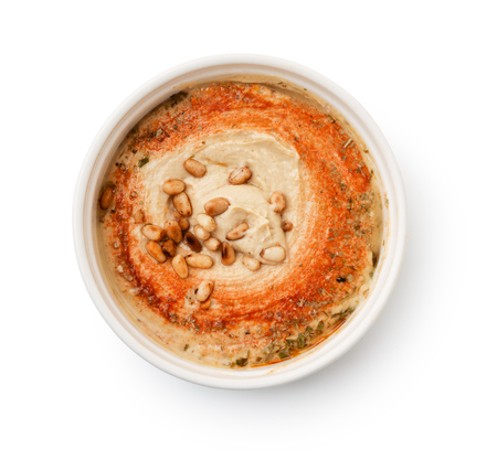 Top view of hummus with pine nuts in bowl isolated on whiteの写真素材