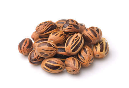 Pile of whole nutmeg with mace isolated on white