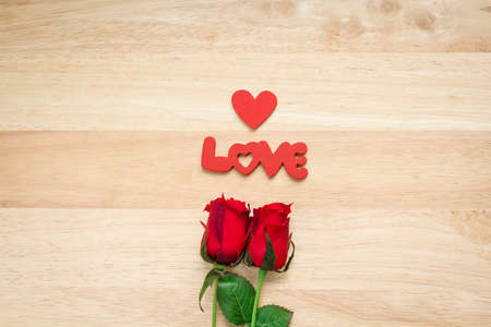 Valentine red roses and love heart on a wooden background.の写真素材