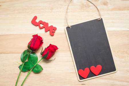 Valentine red roses and love heart on a wooden background.の写真素材