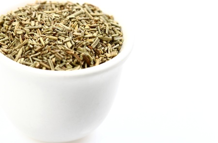 Rosemary dried chopped in a white pot isolated on white background with copyspace on the rightの写真素材