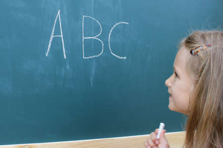 Schoolgirl in front of the blackboardの写真素材