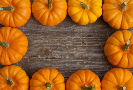 frame with yellow pumpkins on a wooden tableの写真素材