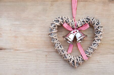 heart with bells on wooden groundの写真素材
