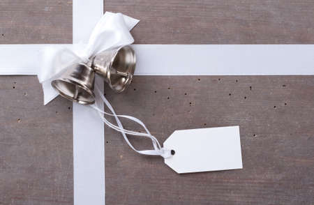 Bells, label and white loop on wooden groundの写真素材