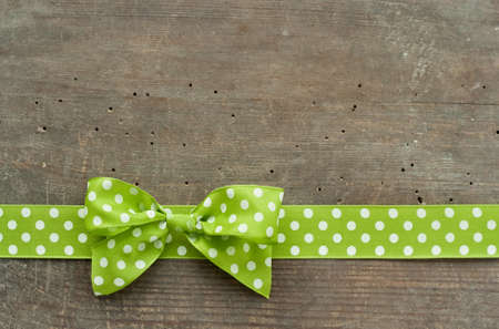 Dotted green loop on wooden groundの写真素材