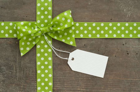 Dotted green loop and white label on wooden groundの写真素材