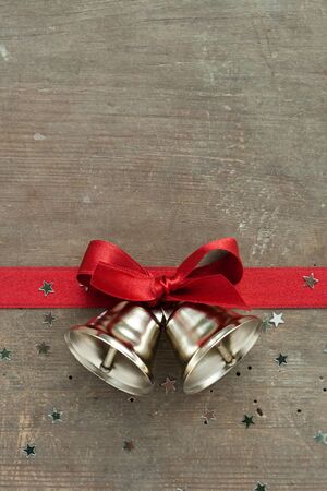 Bells and red loop on wooden groundの写真素材