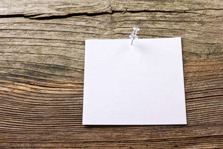 White paper and pin on wooden groundの写真素材