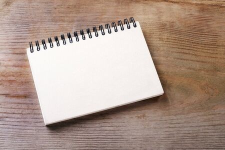White notebook on wooden ground