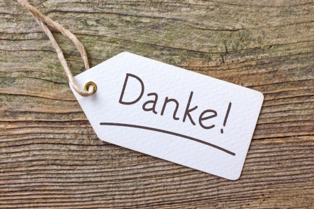 white label with lettering thanks on wooden groundの写真素材