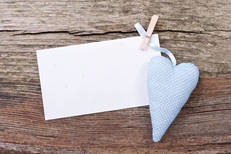 heart and card with close spins on wooden groundの写真素材