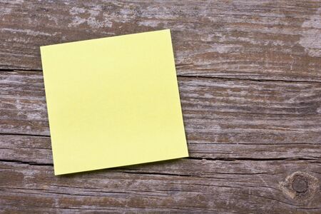 yellow note on wooden ground