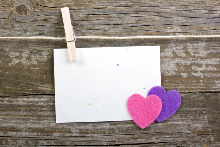 hearts and card with close spins on wooden groundの写真素材