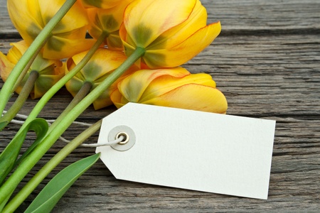 yellow tulips and label on wooden groundの写真素材