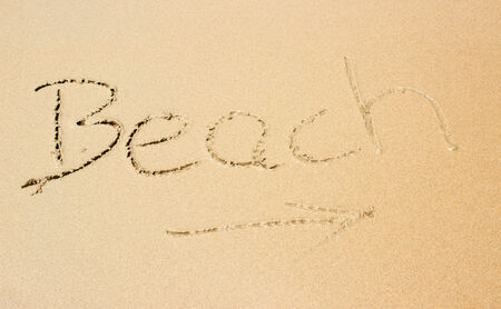 sand with lettering beach and arrowの写真素材