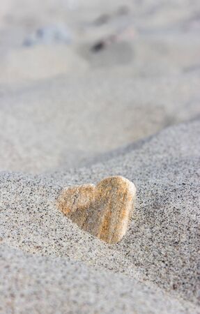 Stone in heart shape in the sand beachの写真素材