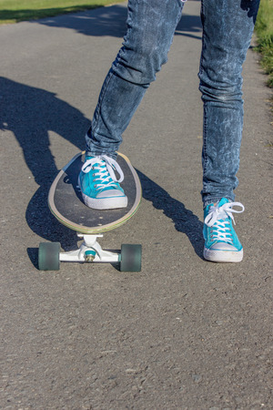 Girl with blue shoes on a skateboardの写真素材
