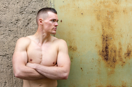 Young, attractive, sporty man leaning against a wallの写真素材