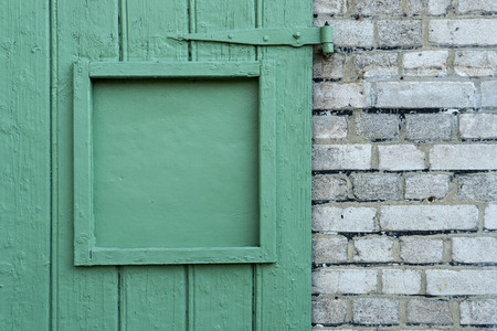 Detail of a green wooden door and a white wallの写真素材