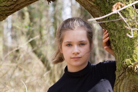 A pretty girl in the forest looks at the cameraの写真素材