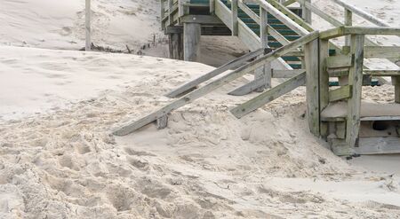 Wooden stairs on the beach are blown with sandの写真素材