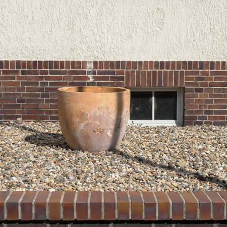Front garden without plants with pebbles and empty terracotta pot in summerの写真素材