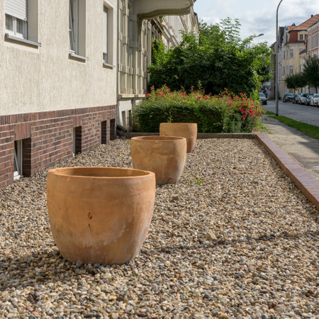 Front garden without plants with pebbles and empty terracotta pots in summerの写真素材