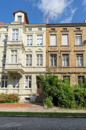 A renovated and a dilapidated terraced house with several floors and a front gardenの写真素材