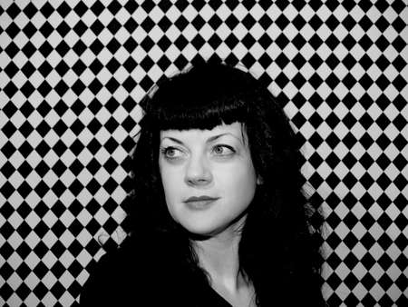 Woman with retro look on black and white checked background.の写真素材