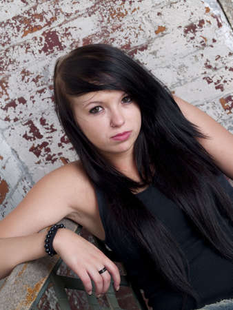 Teen girl on a bench with rustic backgroundの写真素材