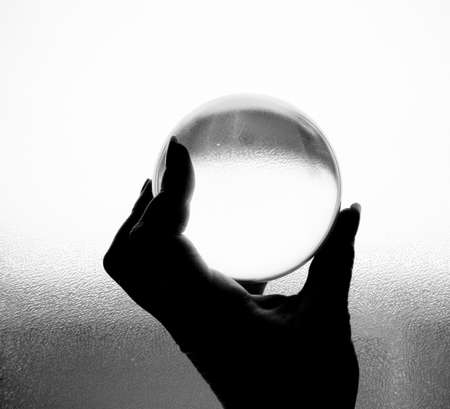 Crystal ball being held in hand in black and whiteの写真素材