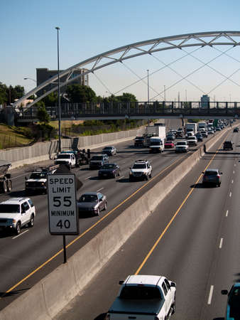 Traffic on the highway with a speed limit sign in the frame.